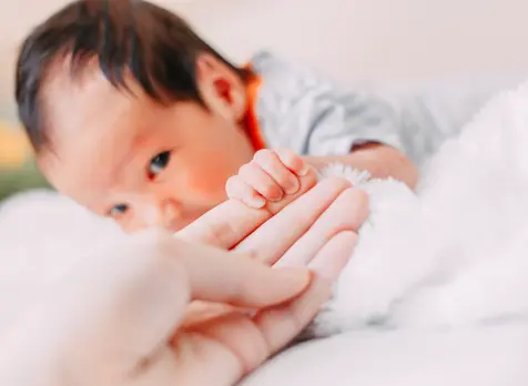 Parent doing tummy time with newborn, supporting newborn milestones