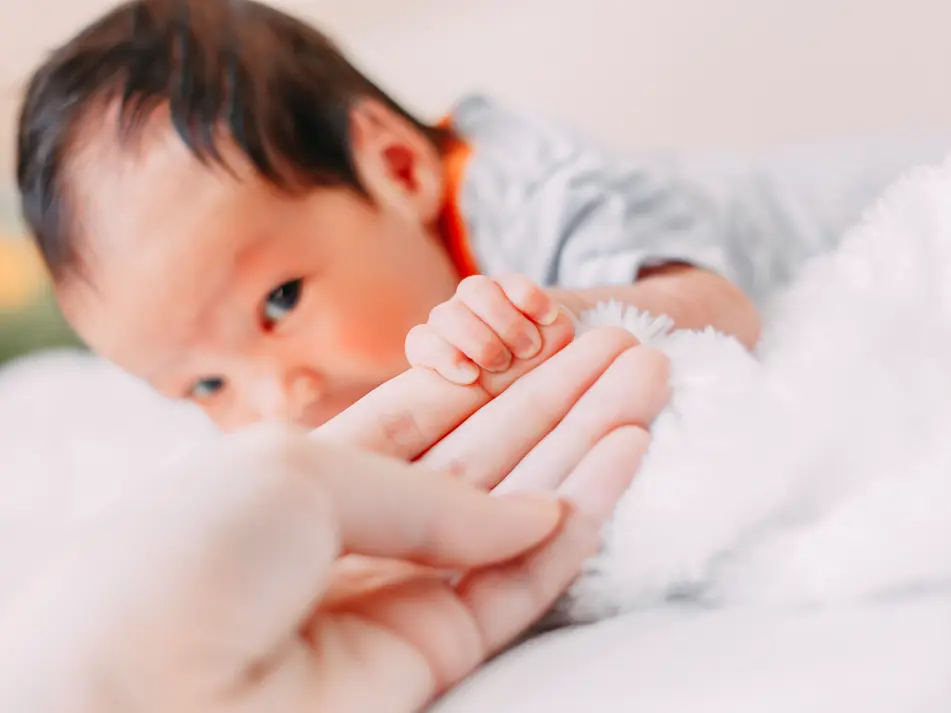 Parent doing tummy time with newborn, supporting newborn milestones