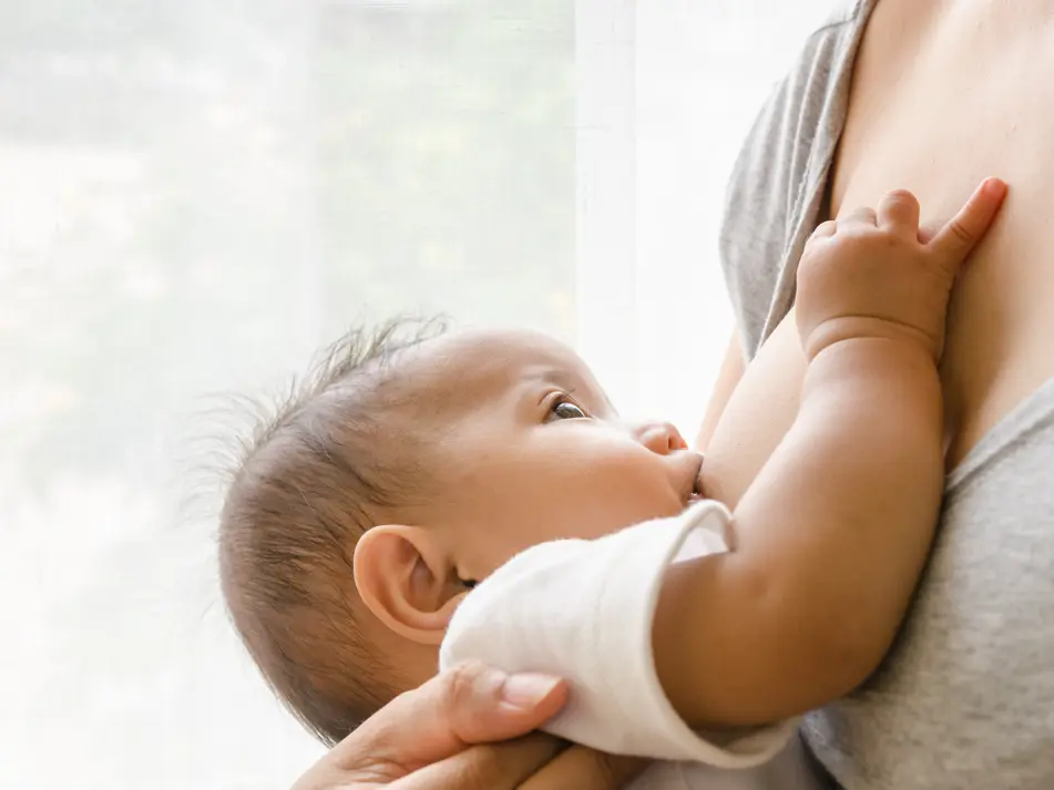 Mother breastfeeding newborn, showing guidance on positioning, attachment and breastfeeding support