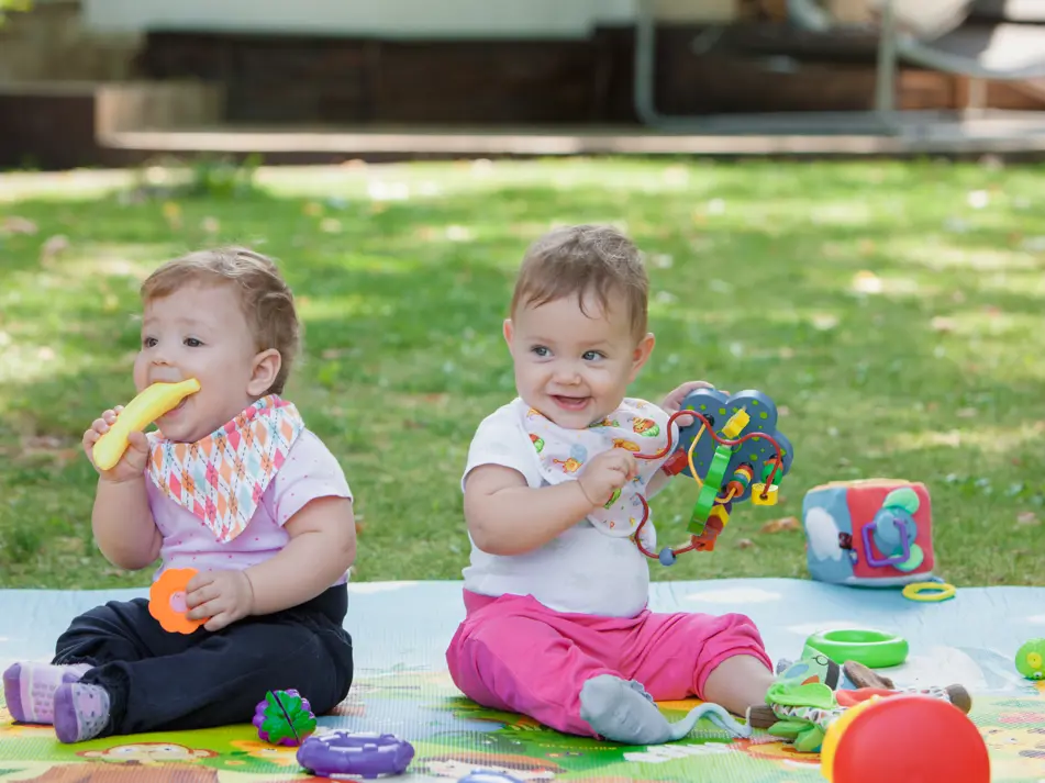Two babies playing in childcare setting, supporting information on starting childcare