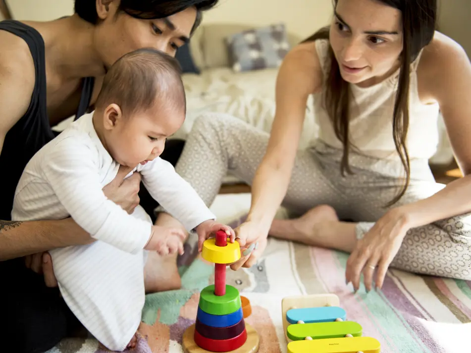 Parents working on baby milestones through play